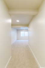 Corridor with baseboards, recessed lighting, and light carpet