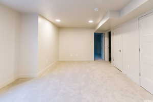 Basement with light colored carpet, baseboards, and recessed lighting