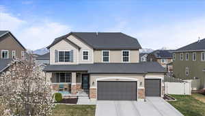 Craftsman Inspired View of front of property with a front yard, stone siding, fence, a gate, and driveway