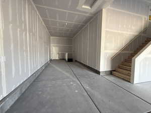 Additional living space featuring stairs and concrete floors