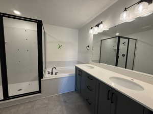 Full bath featuring a bath, a sink, a textured ceiling, a shower stall, and double vanity