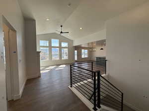 Corridor featuring an upstairs landing, baseboards, vaulted ceiling, and wood finished floors
