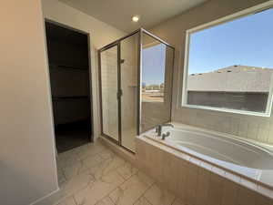 Bathroom with a stall shower, marble finish floors, a garden tub, recessed lighting, and baseboards