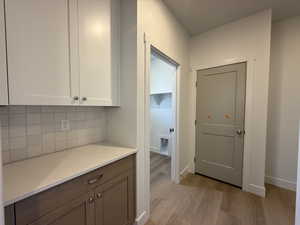 Corridor with light wood-style floors and baseboards