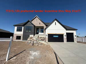 View of front of house with an attached garage, concrete driveway, and fence