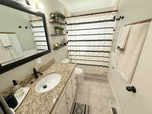 Bathroom with vanity, tile patterned floors, crown molding, toilet, and visible vents