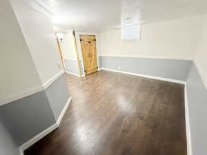 Basement featuring a baseboard heating unit, baseboards, and wood finished floors