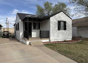 Bungalow featuring covered porch, a front yard, and central AC