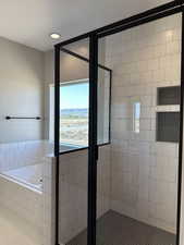 Bathroom with recessed lighting, a garden tub, and a stall shower