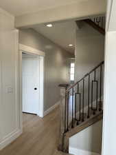 Stairway featuring baseboards, recessed lighting, and wood finished floors
