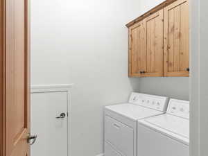 Washroom with independent washer and dryer, storage under the stairs, and cabinet space
