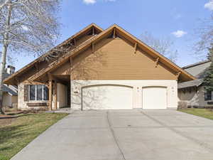 View of front of property featuring a 3 car garage, a front lawn, and concrete driveway