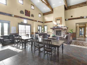 Club house seating area featuring a wainscoted wall, beam ceiling, a stone fireplace, and visible vents