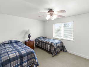 Bedroom with baseboards, carpet flooring, and ceiling fan