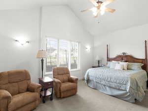 Primary bedroom with high vaulted ceiling, baseboards, a ceiling fan, and carpet floors
