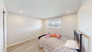 Bedroom featuring baseboards, recessed lighting, and wood finished floors