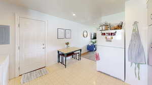 Kitchen featuring freestanding refrigerator, electric panel, and recessed lighting