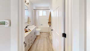 Full bath with toilet, wood finished floors, and vanity