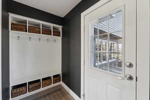 Mudroom featuring dark wood-type flooring, a textured ceiling, and baseboards