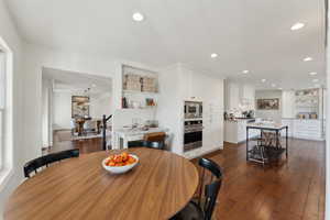 Dining area featuring dark wood-type flooring and recessed lighting