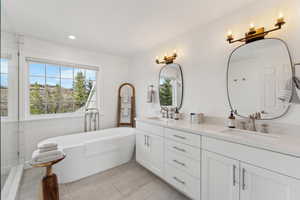Bathroom featuring a healthy amount of sunlight, double vanity, and a sink