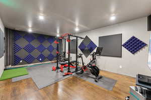Exercise room featuring recessed lighting, golf simulator, and wood finished floors