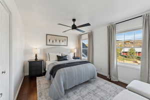 Bedroom featuring ceiling fan, baseboards, and dark wood finished floors