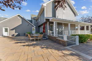 Back of property featuring a porch, outdoor dining area, and a patio area
