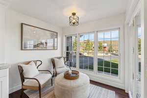 Sitting room with a chandelier, wood finished floors, and baseboards