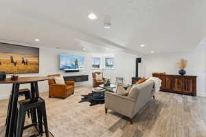 Living room featuring light wood-style flooring, recessed lighting, and baseboards