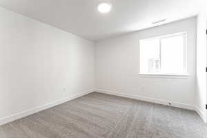 Empty room featuring carpet and a textured ceiling