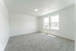 Carpeted empty room with baseboards and a textured ceiling