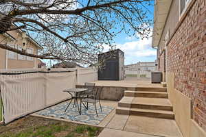 View of patio / terrace with a storage shed, fence