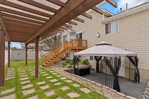 View of patio / terrace with a cloth-covered gazebo, fence, an outdoor structure, and a storage shed
