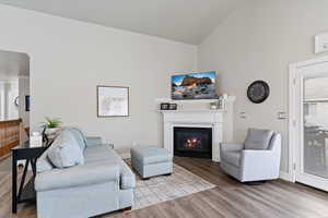 Living room with baseboards, high vaulted ceiling, gas log fireplace, French doors
