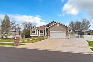 View of front of home featuring a garage, a front yard, fence, stucco and brick siding, and RV parking