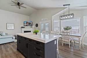 Kitchen featuring vaulted ceiling, a center island, open floor plan, and LVP  flooring
