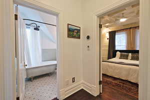 Hall featuring dark wood-type flooring, coffered ceiling, and a wainscoted wall