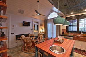 Dining space with a ceiling fan, lofted ceiling, and visible vents