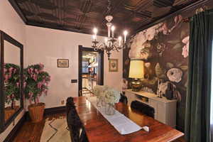Dining space featuring an ornate ceiling, a notable chandelier, and wood finished floors