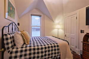 Bedroom featuring dark wood-type flooring and lofted ceiling
