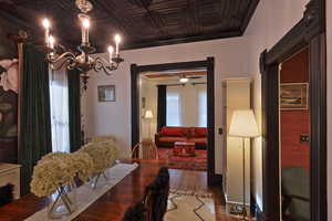 Dining area with an ornate ceiling, ceiling fan with notable chandelier, and wood finished floors