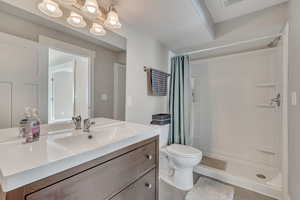 Full bath with a shower stall, vanity, and toilet