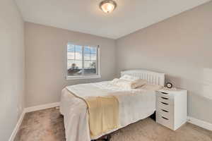 Bedroom featuring light colored carpet and baseboards