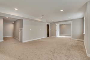 Spare room featuring light colored carpet, baseboards, visible vents, and recessed lighting