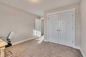 Unfurnished office featuring baseboards and carpet