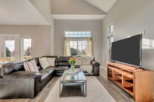 Living area with high vaulted ceiling and wood finished floors