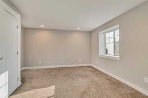 Carpeted spare room with baseboards and recessed lighting