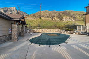 View of swimming pool with a patio area, a mountain view, and fence