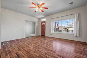 Unfurnished living room with wood finished floors, ceiling fan, and visible vents